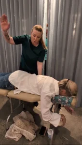 Kath Whitehorn providing a Spinal Energetics session with a client resting face down on a treatment table at Hill Tribe Healing.