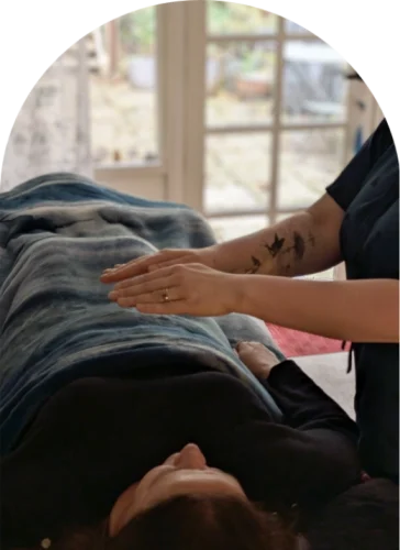 Kath Whitehorn providing a reiki session with a client resting on a treatment table at Hill Tribe Healing in the Dandenongs